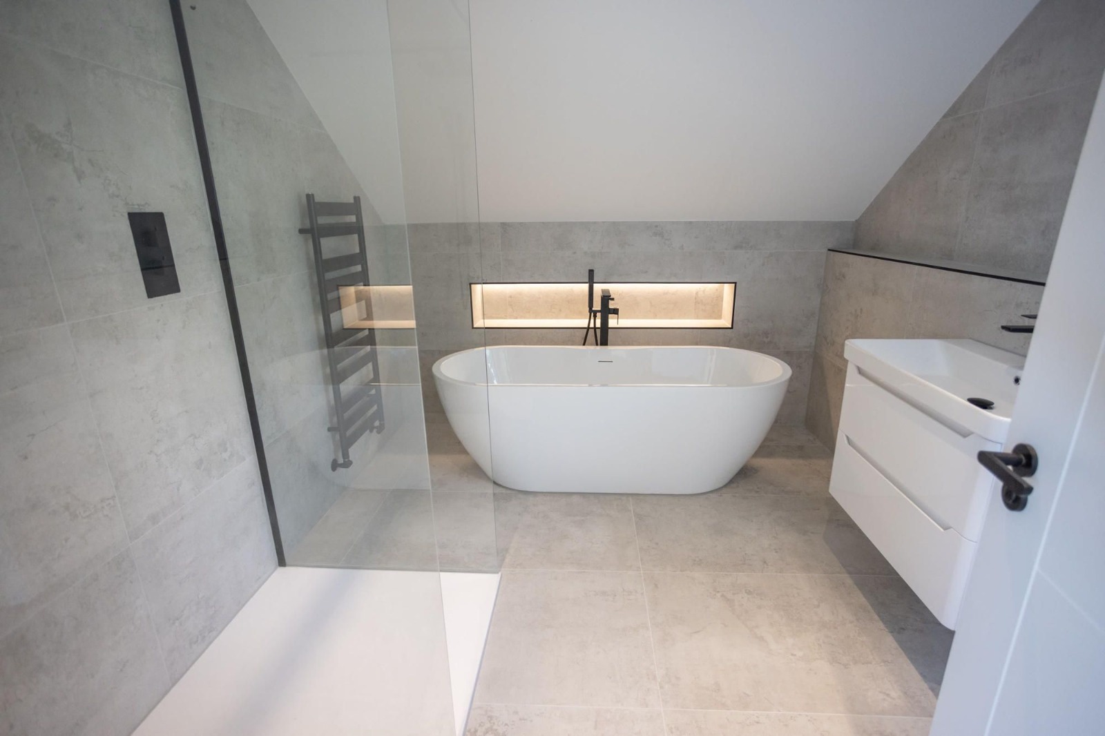 Tiled bathroom with a freestanding bath, walk-in shower and lit recess