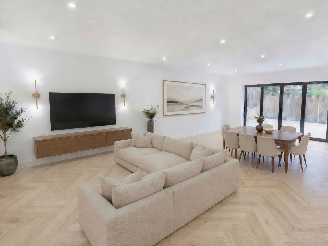 Open-plan living and dining room with herringbone flooring and bi-fold doors